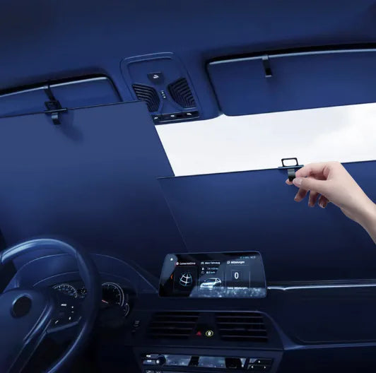 Hand adjusting a sunshade in a car's sunroof.